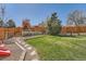 Manicured backyard featuring a grass yard, stone walkway, playground set, and wooden fence at 5157 S Sedalia Ct, Centennial, CO 80015