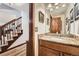 Bathroom featuring granite countertop vanity and wood floors, adjacent to stairway with carpet at 5157 S Sedalia Ct, Centennial, CO 80015