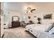 Bright bedroom with a decorative comforter, ceiling fan, sitting area with two chairs, and carpeted floors at 5157 S Sedalia Ct, Centennial, CO 80015