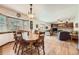 Bright dining area with hardwood floors, a bay window, and access to the living room and outdoor space at 5157 S Sedalia Ct, Centennial, CO 80015