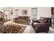 Cozy living room featuring a plush sofa and a leather armchair with natural light from windows at 5157 S Sedalia Ct, Centennial, CO 80015