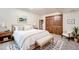 Stylized primary bedroom with a neutral color palette, closet with folding doors, and a decorative bench at 5157 S Sedalia Ct, Centennial, CO 80015