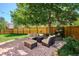 Cozy backyard patio has comfortable seating, a fire pit, and shade from a mature tree at 7804 Silverweed Way, Lone Tree, CO 80124