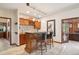 Home bar featuring a tiled backsplash, pendant lighting, seating, and a seamless transition to an office space at 7804 Silverweed Way, Lone Tree, CO 80124