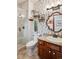 Charming bathroom featuring a glass-enclosed shower, stylish wallpaper, and a modern sink with granite countertop at 7804 Silverweed Way, Lone Tree, CO 80124