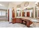 Elegant bathroom featuring custom cabinetry, granite countertops, dual sinks, a soaking tub, and decorative accents at 7804 Silverweed Way, Lone Tree, CO 80124