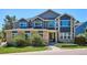 Two-story home showcasing a brick and navy blue exterior with a well-manicured lawn and mature shrubs at 7804 Silverweed Way, Lone Tree, CO 80124