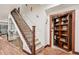 Inviting hallway featuring an elegant staircase and a hidden bookcase at 7804 Silverweed Way, Lone Tree, CO 80124