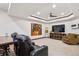 Relaxing living room with a tray ceiling, a modern fireplace, and comfortable seating at 7804 Silverweed Way, Lone Tree, CO 80124