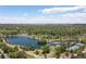 Wide aerial shot capturing lake, greenery, tennis courts and surrounding landscape under a bright sky at 1121 S Ogden St, Denver, CO 80210