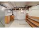 Basement space with exposed ceiling fixtures, shelving, wooden cabinets, and two small windows at 1121 S Ogden St, Denver, CO 80210
