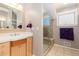 Bathroom featuring a glass enclosed shower with tile surround, wood vanity, and a neutral color palette at 1121 S Ogden St, Denver, CO 80210