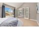 Bright bedroom features carpet floors, fresh paint, a large window and an ensuite bathroom at 1121 S Ogden St, Denver, CO 80210