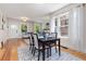 Bright dining room with a dark table set, hardwood floors, and large windows at 1121 S Ogden St, Denver, CO 80210