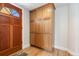 Entryway with a solid wood front door, hardwood flooring, and a large storage cabinet at 1121 S Ogden St, Denver, CO 80210