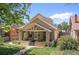 Charming front exterior featuring a covered porch with a well-manicured lawn and a brick facade at 1121 S Ogden St, Denver, CO 80210