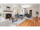 Elegant living room showcasing a cozy fireplace, wood floors and adjacent dining area at 1121 S Ogden St, Denver, CO 80210