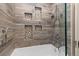 Beautifully tiled shower and tub featuring decorative recessed tile and glass enclosure at 1121 S Ogden St, Denver, CO 80210