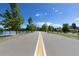 Street view along lake showing yellow-striped road with lake, mature trees, and blue skies at 1121 S Ogden St, Denver, CO 80210
