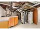 Unfinished utility room featuring a furnace, water heater, and storage cabinets at 1121 S Ogden St, Denver, CO 80210