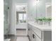 Modern bathroom featuring double sinks, quartz countertops, and a view into an adjacent bedroom at 2436 Welton St, Denver, CO 80205