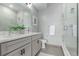 Modern bathroom featuring double sinks, light gray cabinets, quartz countertops, and a glass-enclosed shower at 2436 Welton St, Denver, CO 80205