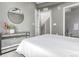 Bright bedroom with neutral walls, a minimalist glass console, and a contemporary round mirror at 2436 Welton St, Denver, CO 80205