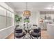 Dining room open to the kitchen, with a round glass table and stylish pendant lighting fixture at 2436 Welton St, Denver, CO 80205