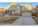 Two-story house with green siding, brick accents, and a spacious driveway at 3914 S Perth St, Aurora, CO 80013