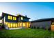 Backyard of a modern home featuring large windows, lush green lawn, and modern design at 1110 Elm St, Denver, CO 80220