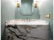 Stylish powder room featuring a marble countertop vanity and modern gold fixtures at 1110 Elm St, Denver, CO 80220