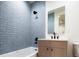 Bathroom featuring light blue subway tiles in shower, a black shower head, and modern vanity at 1110 Elm St, Denver, CO 80220