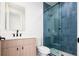 Modern bathroom showcasing blue tiled shower with glass door, neutral vanity, and updated fixtures at 1110 Elm St, Denver, CO 80220