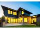 Modern home with a combination of brick and dark siding, large windows, and a manicured lawn at 1110 Elm St, Denver, CO 80220