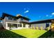 Modern house boasting a green lawn, dark siding, and large windows against a beautiful blue sky at 1110 Elm St, Denver, CO 80220