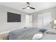 This bright bedroom features a modern ceiling fan, large television, and a large closet with sliding doors at 3657 Krameria St, Denver, CO 80207