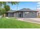 Beautifully landscaped front yard leads to this home with a striking dark exterior and modern windows at 3657 Krameria St, Denver, CO 80207