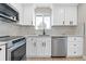 Bright kitchen with stainless steel appliances, white cabinets, and natural light from the window at 3657 Krameria St, Denver, CO 80207