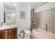 Neutral toned bathroom features a vanity, toilet, and tub/shower combination with tile surround at 7611 S Addison Way, Aurora, CO 80016