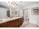 Bathroom featuring a double vanity, tiled floor, framed mirror and walk-in shower at 7611 S Addison Way, Aurora, CO 80016