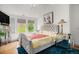 Bedroom features a tufted headboard, modern chandelier, and natural light at 7611 S Addison Way, Aurora, CO 80016