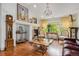 Living room with fireplace, hardwood floors, decorative chandelier, and bright view of outdoors at 7611 S Addison Way, Aurora, CO 80016