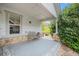 Covered porch with stone accents and a cozy seating area overlooks the landscaped backyard at 7611 S Addison Way, Aurora, CO 80016