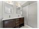 Contemporary bathroom featuring double sinks, dark wood cabinetry, and a glass-enclosed shower at 9628 Dunning Cir, Highlands Ranch, CO 80126