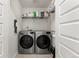 Well-lit laundry room featuring modern washer and dryer units with ample shelving at 9628 Dunning Cir, Highlands Ranch, CO 80126