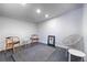 Bright bonus room with black floor, white walls and ceiling, modern furniture and an artistic accent at 2545 S Lowell Blvd, Denver, CO 80219