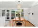 Bright dining room features a sleek light fixture, hardwood floors, and large windows with an exterior view at 2545 S Lowell Blvd, Denver, CO 80219