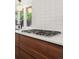 Cooktop and backsplash in a modern kitchen with white countertops and wood cabinets at 2545 S Lowell Blvd, Denver, CO 80219