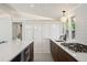 Sleek kitchen with a quartz countertop, white cabinets, dark wood cabinets, and modern appliances at 2545 S Lowell Blvd, Denver, CO 80219