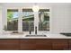 Close up of the kitchen sink and counter with wood cabinets below and view from the window at 2545 S Lowell Blvd, Denver, CO 80219